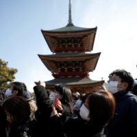 People take photos during the annual bean-scattering ceremony at the Naritasan Shinshoji temple in Narita, Chiba Prefecture, on Thursday. | REUTERS
