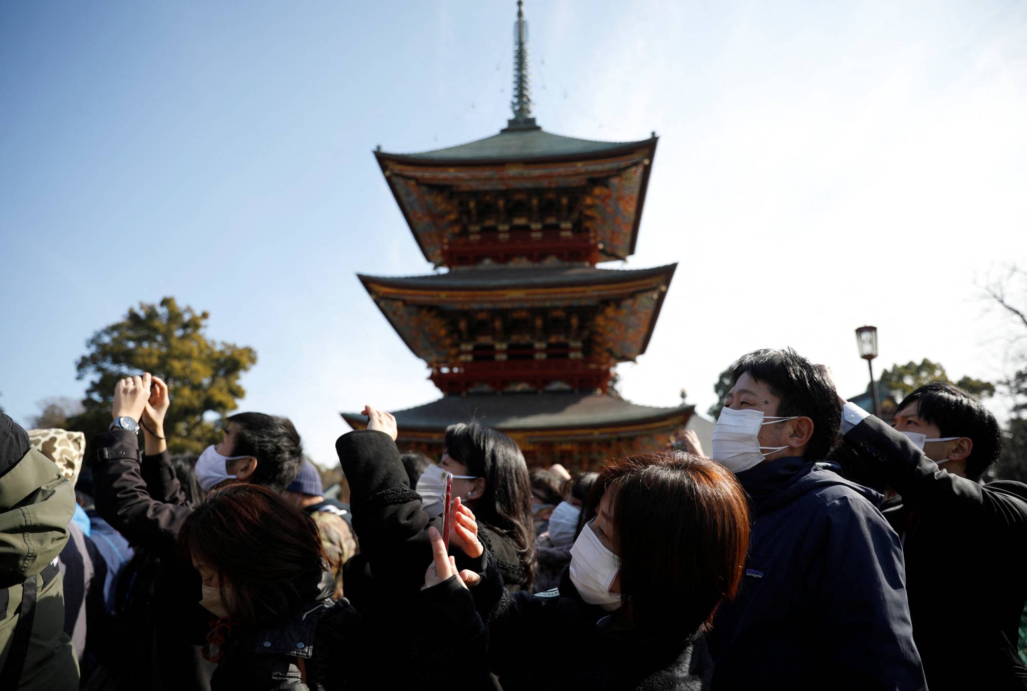 People take photos during the annual bean-scattering ceremony at the Naritasan Shinshoji temple in Narita, Chiba Prefecture, on Thursday. | REUTERS 