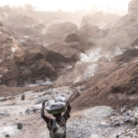 A woman carries out a pan of granite up the side of a granite mine in Burkina Faso late last month.  | AFP-JIJI