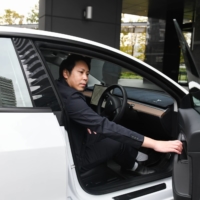 Tatsuya Arai in his Tesla electric vehicle in Tokyo | BLOOMBERG