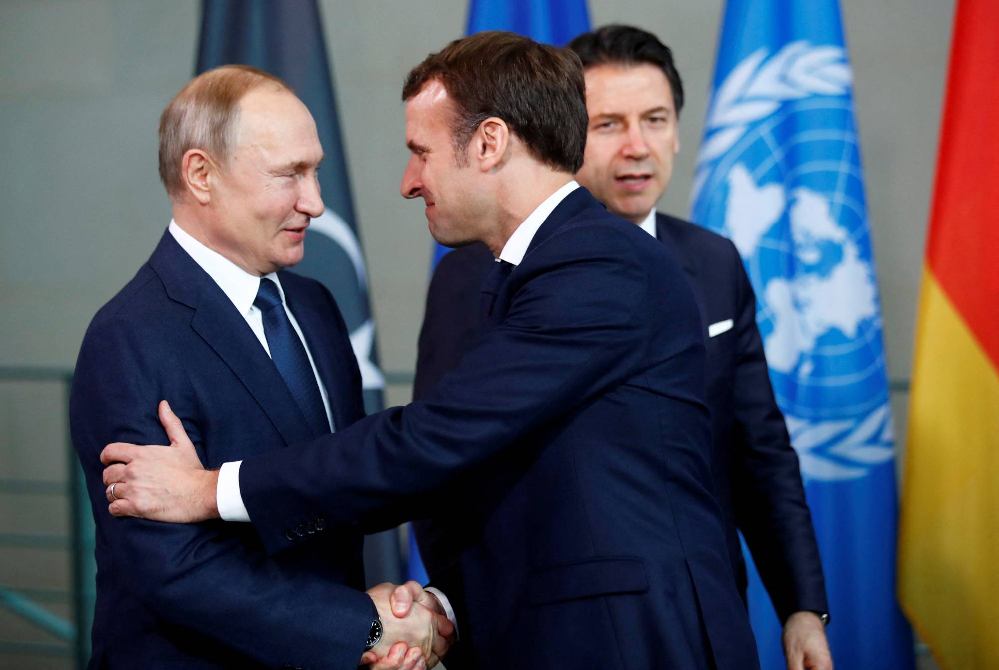 Russian President Vladimir Putin shakes hands with French President Emmanuel Macron during the Libya summit in Berlin on Jan. 19. | REUTERS