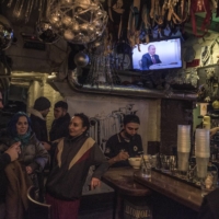 Russian President Vladimir Putin is seen on TV at a bar during his meeting with Hungarian President Viktor Orban in Moscow on Feb. 1. | SERGEY PONOMAREV / THE NEW YORK TIMES