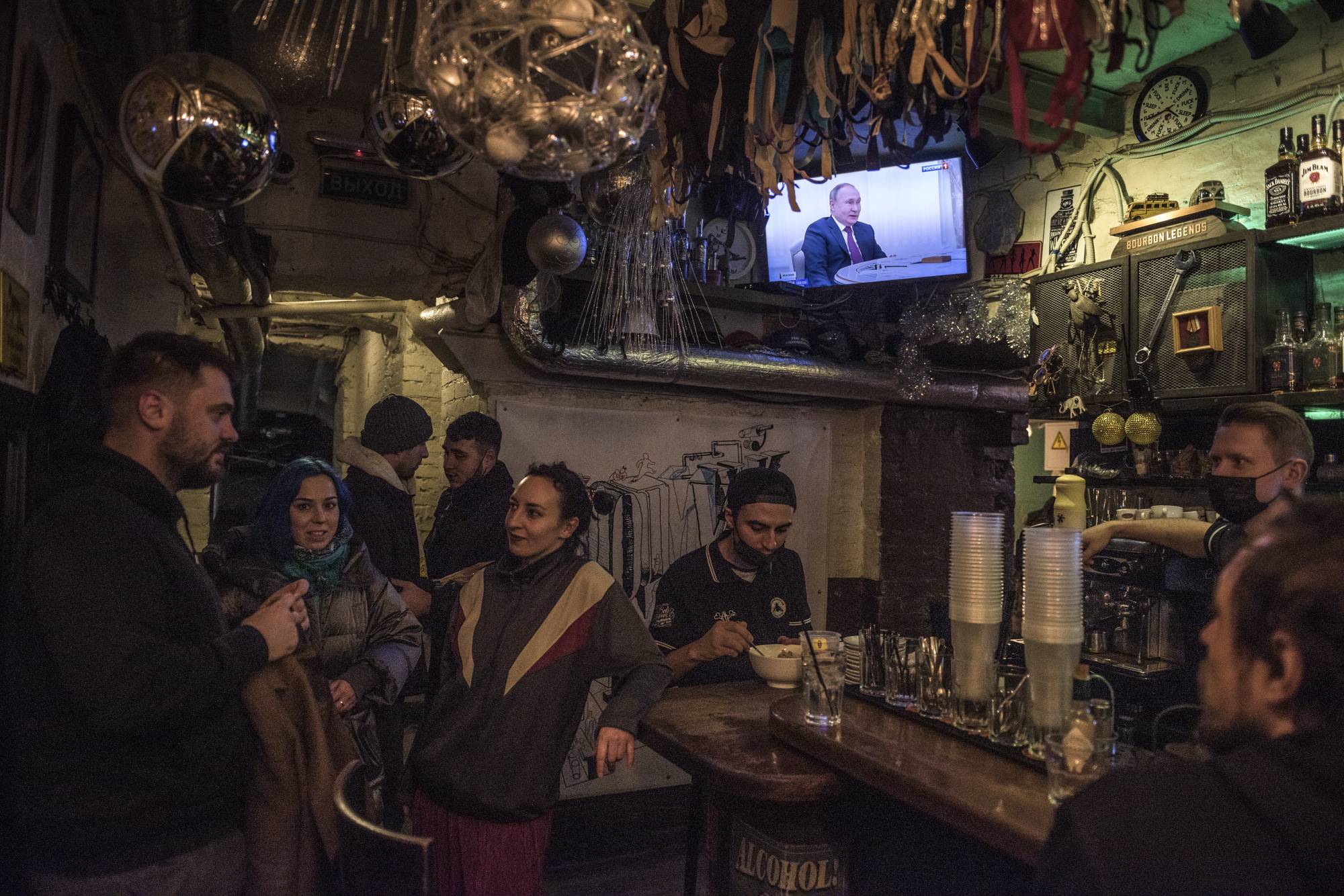 Russian President Vladimir Putin is seen on TV at a bar during his meeting with Hungarian President Viktor Orban in Moscow on Feb. 1. | Sergey Ponomarev / The New York Times