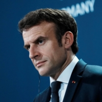 French President Emmanuel Macron looks on during a news conference in Berlin on Tuesday. | POOL / VIA REUTERS 