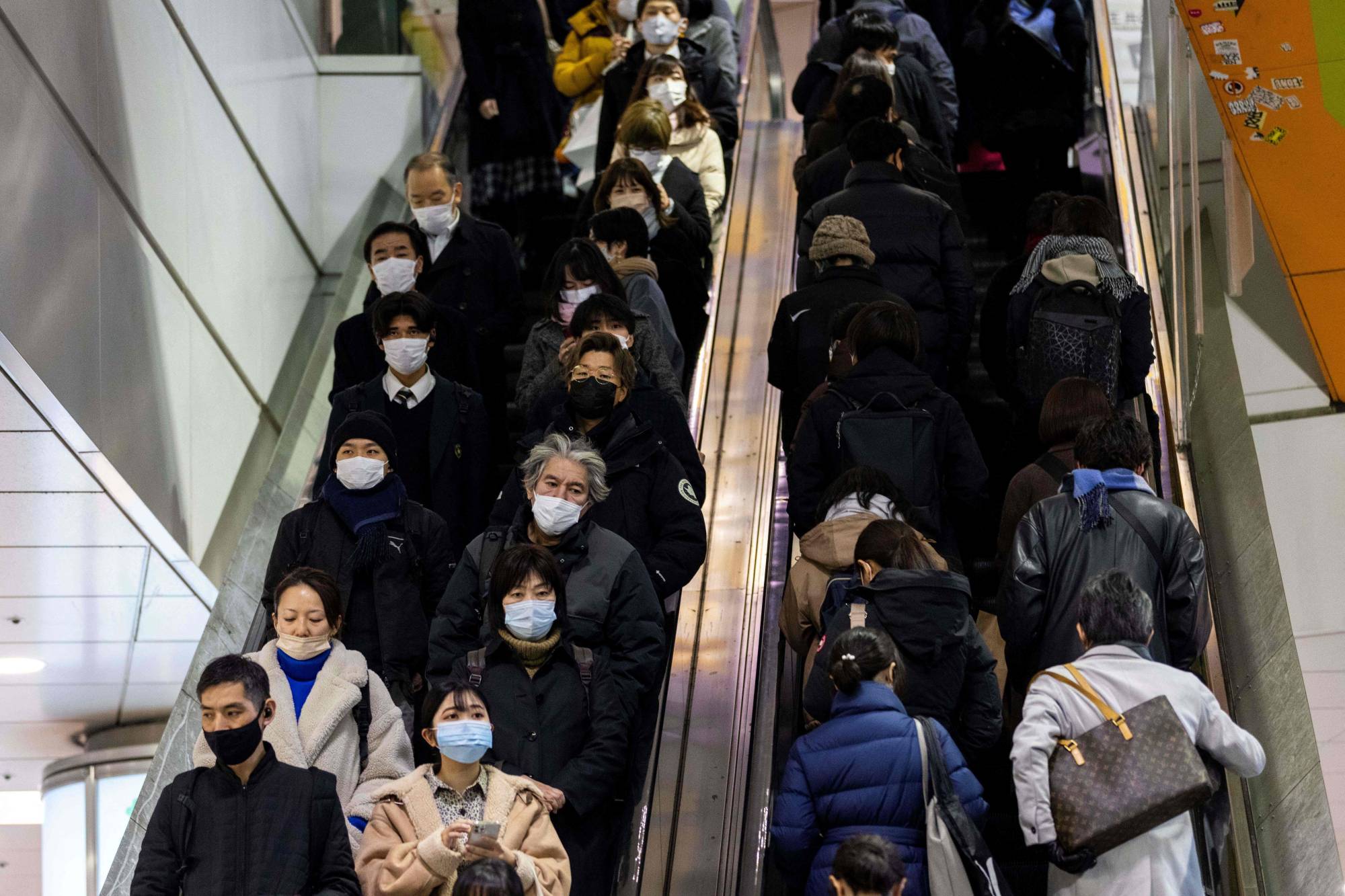 People in Tokyo's Shibuya district on Jan. 19. In Japan, labor unions and the management side are said to focus more on simply protecting employment itself rather than on raising wages. | AFP-JIJI