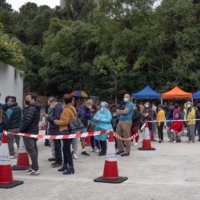 Residents wait in line at a COVID-19 testing facility in Hong Kong on Wednesday. | BLOOMBERG
