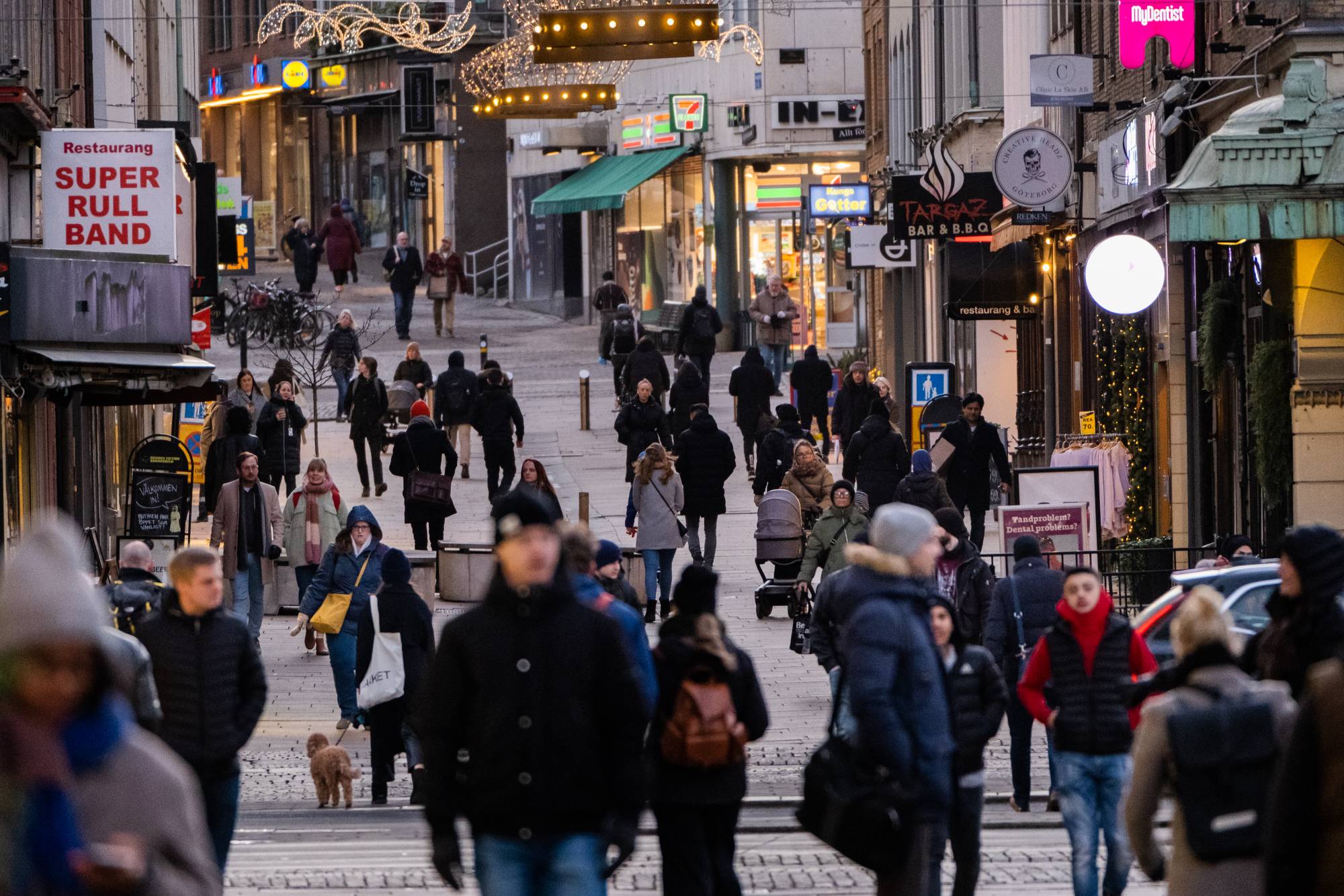 Shoppers walk along Kungsgatan street following the removal of coronavirus restrictions, in central Gothenburg, Sweden, on Wednesday. Sweden began phasing out most of its current pandemic prevention measures — the decision coinciding with Wednesday's lifting of most restrictions. | BLOOMBERG