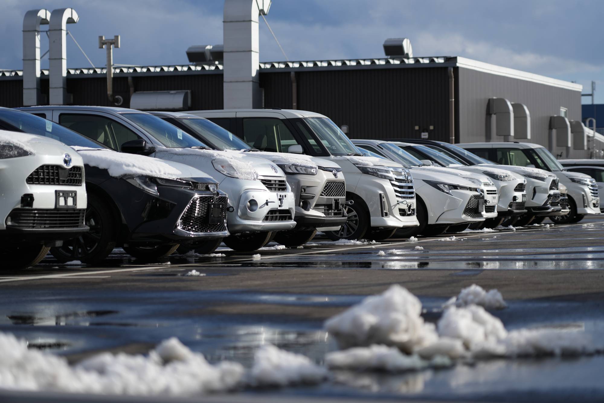 Toyota Motor Corp. vehicles parked at a company dealership in Sendai on Feb. 5. The pandemic has disrupted global supply chains, causing shortages of critical products. | BLOOMBERG