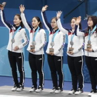 South Korea’s women’s curling team — Kim Eun-jung, Kim Kyeong-ae, Kim Seon-yeong, Kim Yeong-mi and Kim Cho-hi —  with their silver medals during the 2018 Winter Olympics in Pyeongchang | CHANG W. LEE / THE NEW YORK TIMES