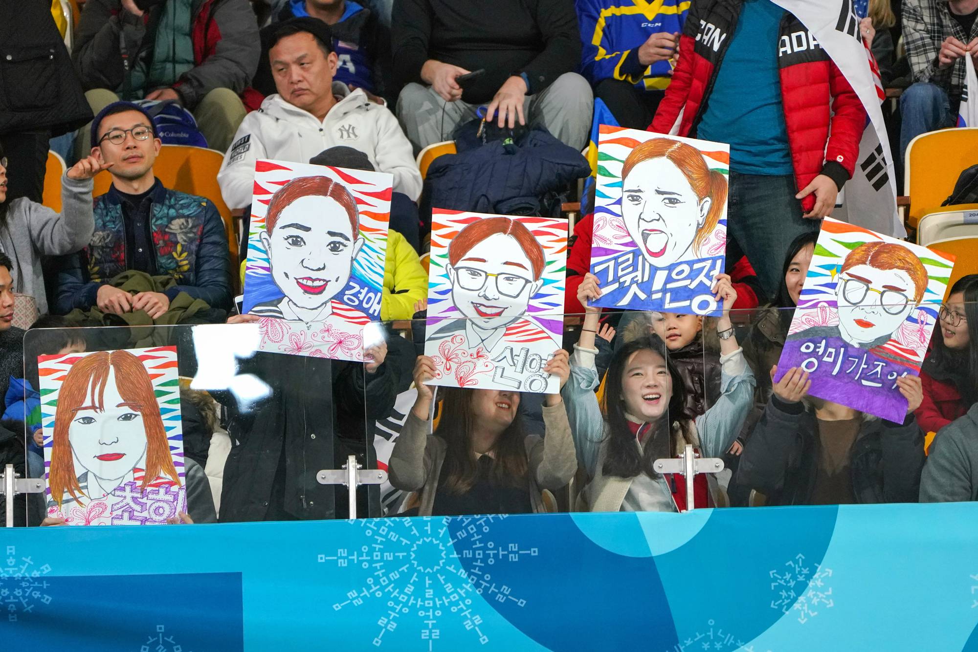 Fans hold drawings of the South Korean women's curling team during the 2018 Pyeongchang Olympics in South Korea. | Chang W. Lee / The New York Times
