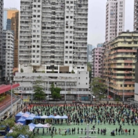 People queue at a mobile specimen collection station for COVID-19 testing in Hong Kong\'s Mongkok district on Thursday. Hong Kong\'s current social distancing rules aren\'t enough to bring the city\'s record-setting COVID-19 wave under control, and nearly 1,000 residents may die by mid-June if there aren\'t changes, according to researchers. | AFP-JIJI