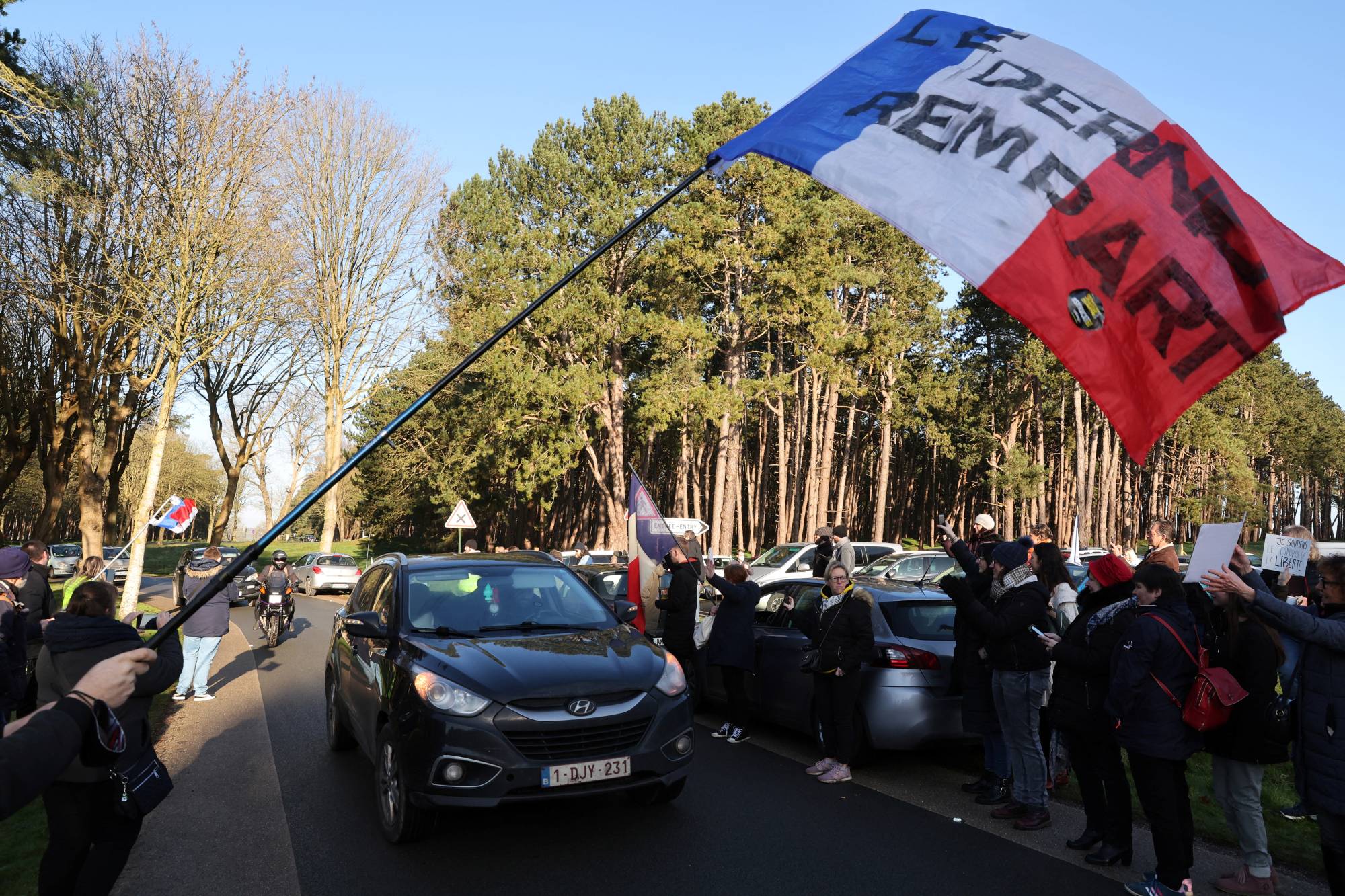 Protesters against COVID-19 restrictions near the Canadian National Memorial in Vimy, northern France, on Friday. | REUTERS