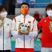 Gold medalist Gao Tingyu of China celebrates on the podium next to South Korea\'s Cha Min-kyu and Japan\'s Wataru Morishige.  | REUTERS