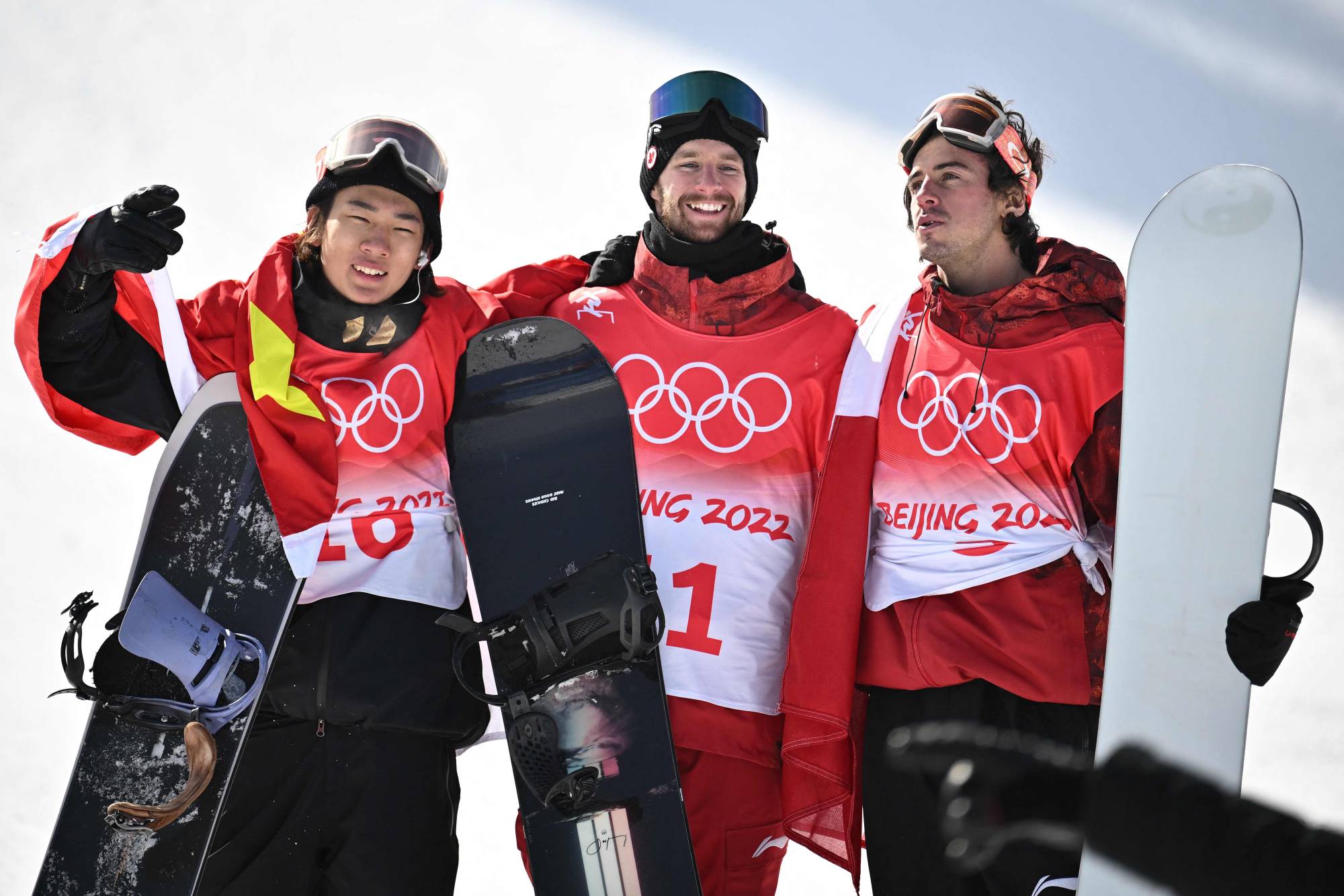 Men's slopestyle winner Max Parrot (center) poses with runner-up Su Yiming (left) and bronze medalist Mark McMorris after the Olympic final in Zhangjiakou, China, on Monday. | AFP-JIJI