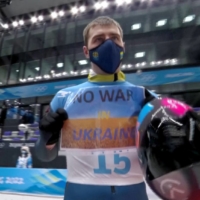 Ukraine\'s Vladyslav Heraskevych holds a sign with a message reading \"NO WAR IN UKRAINE\" during the Beijing Olympic skeleton competition on Friday.  | IOC / OBS / VIA REUTERS