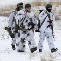 Ukrainian service members walk with weapons supplied by the United States during drills at the International Peacekeeping Security Center near Yavoriv in the country\'s Lviv region, on Feb. 4. | REUTERS