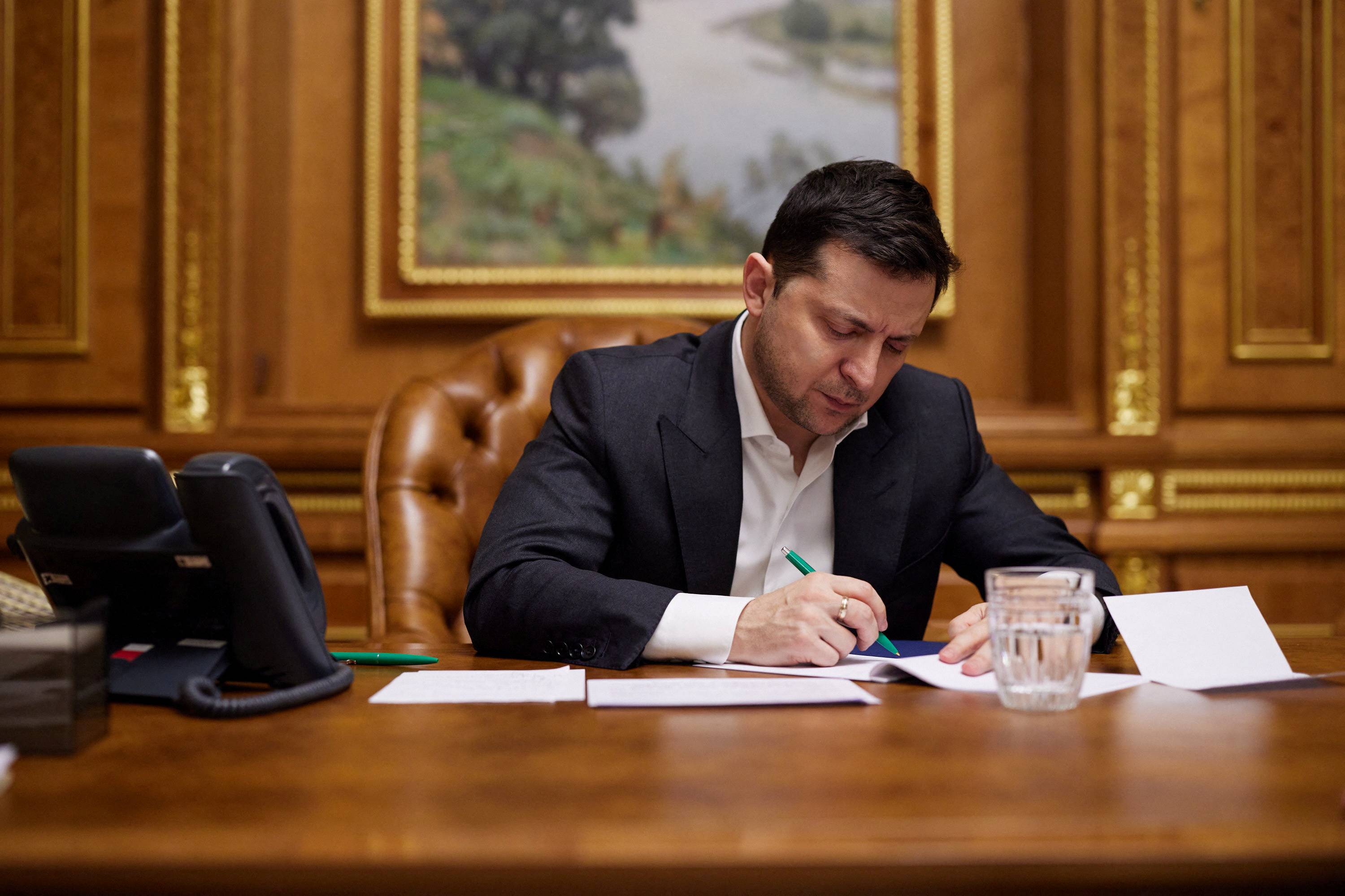 Ukrainian President Volodymyr Zelenskiy listens during a call with U.S. President Joe Biden in Kyiv on Sunday. | Ukrainian Presidential Press Service / via REUTERS
