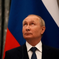 Russian President Vladimir Putin looks up during a joint news conference with French leader Emmanuel Macron after their talks in Moscow on Feb. 7. | POOL / VIA REUTERS