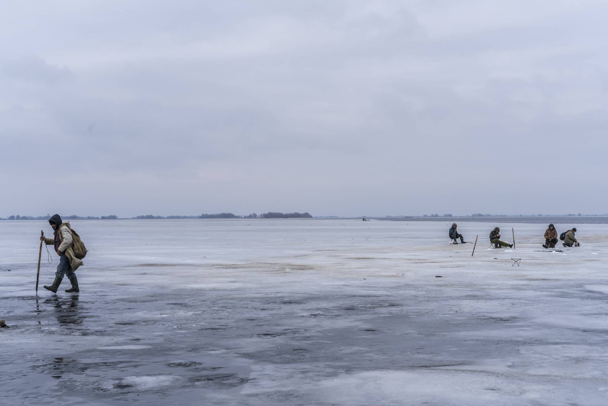 Ice fishermen on the Dnieper River in Cherkasy, Ukraine on Thursday.  | BRENDAN HOFFMAN / THE NEW YORK TIMES