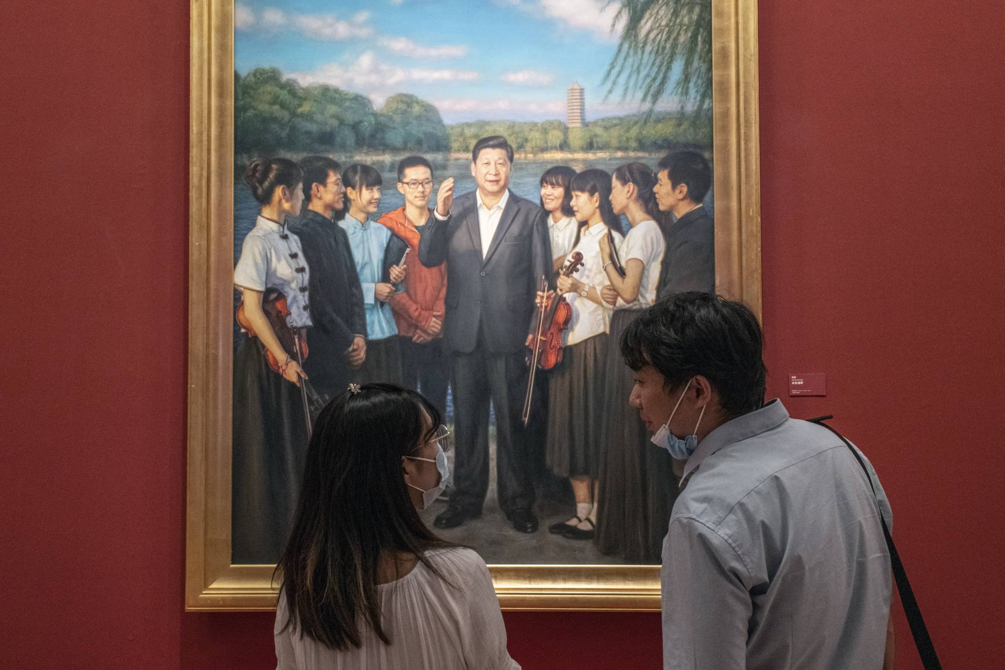 Visitors in front of a portrait of Xi Jinping at the National Art Museum in Beijing during the exhibition “100 years toward greatness” in June, 2021. A century after the Communist Party’s founding, Xi Jinping, China’s leader, said foreign powers would “crack their heads and spill blood” if they tried to stop its rise. | Gilles Sabriz / The New York Times