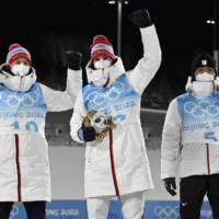 Silver medalist Norway\'s Jens Luraas Oftebro (left), gold medalist Norway\'s Joergen Graabak (center) and bronze medalist Akito Watabe of Japan celebrate on the podium after the cross-country race of the Nordic Combined men\'s individual large hill 10-kilometer event during the 2022 Beijing Winter Olympics at the Zhangjiakou National Cross-Country Skiing Centre on Tuesday. | AFP-JIJI