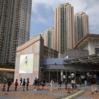 Residents queue at a COVID-19 testing facility in Hong Kong, on Tuesday. Hong Kong’s leader said the city had no plans for a citywide lockdown to help bring cases back to zero, even as she acknowledged that a growing omicron outbreak has exceeded its capacity to respond.  | BLOOMBERG