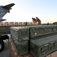 Ukrainian Military servicemen load a flatbed truck with boxes of U.S.-made weaponry at Boryspil Airport, near Kyiv, on Sunday. | AFP-JIJI