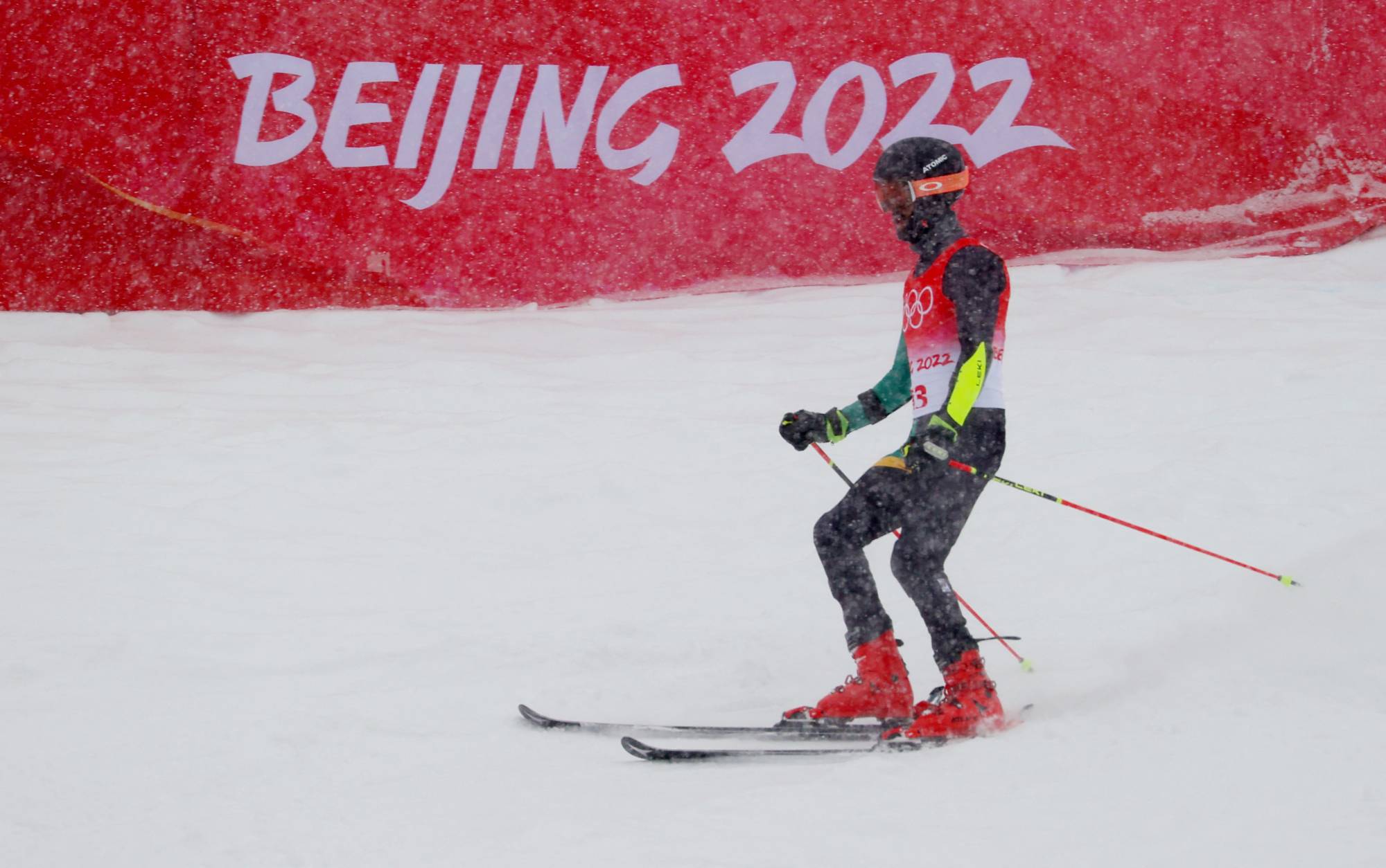 Benjamin Alexander of Jamaica slides into the judging area after his men's giant slalom run at the 2022 Beijing Winter Olympics on Sunday. | REUTERS