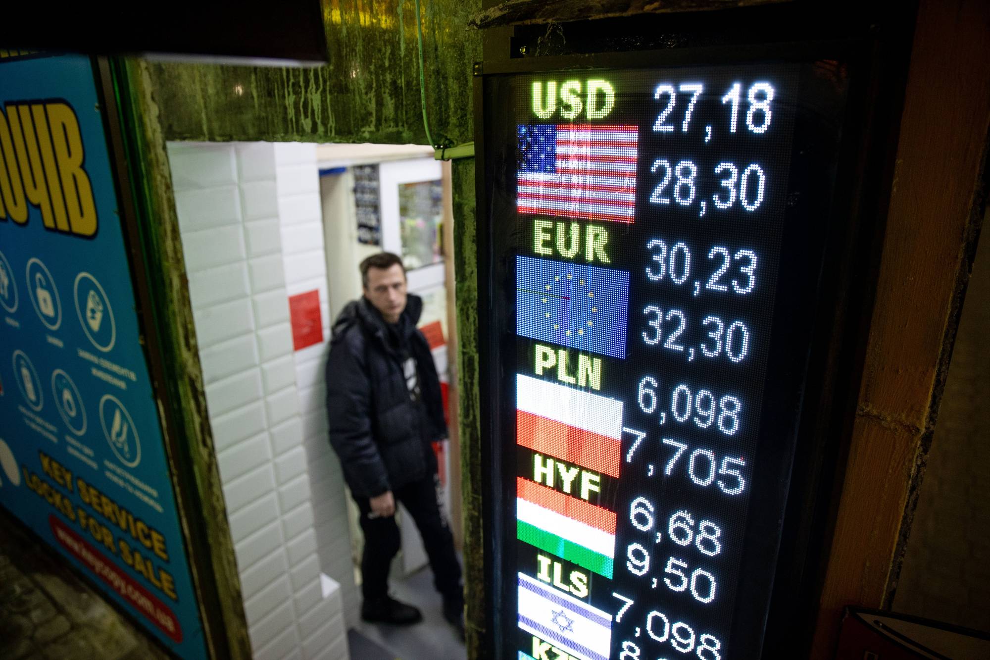 A customer exits a currency exchange kiosk in Kyiv on Tuesday. | BLOOMBERG