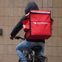 A Doordash delivery worker rides in the rain during the COVID-19 pandemic in New York City on Nov. 13, 2020.  | REUTERS