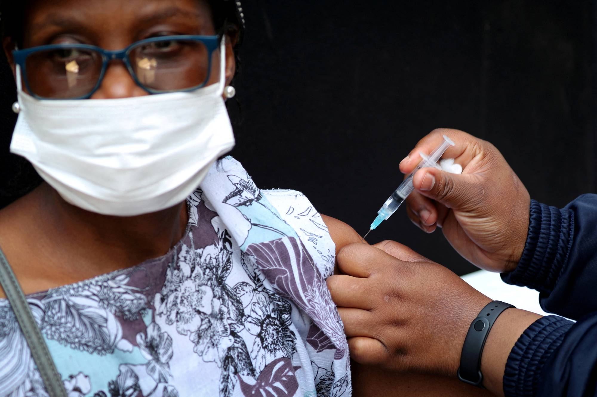 A health care worker administers the Johnson & Johnson COVID-19 vaccination to a woman in Johannesburg on Aug. 20. | REUTERS