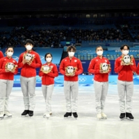 The Japanese team poses on the ice after the Beijing Olympic figure skating team event on Feb. 7. | AFP-JIJI