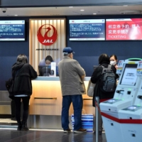 A check-in counter at Tokyo\'s Haneda Airport on Wednesday. As more people get infected with the highly transmissible omicron variant of the coronavirus, experts say there is no reason to keep the borders closed any longer.  | AFP-JIJI