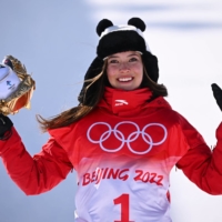 Eileen Gu poses for photos on the podium after winning the Beijing Olympic  women\'s freestyle skiing halfpipe event on Friday. | REUTERS