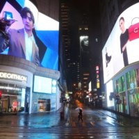 A pedestrian crosses a street in the shopping area of Hong Kong\'s Central district, following a surge in cases of COVID-19 in the territory on Sunday. | REUTERS
