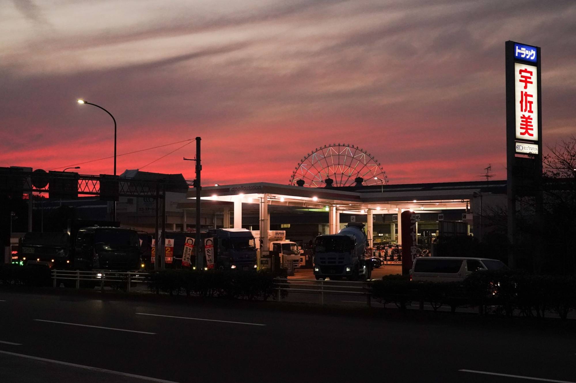 A Ferris wheel behind an Idemitsu Kosan Co. gas station at dusk in Tokyo in Nov., 2021 | Bloomberg