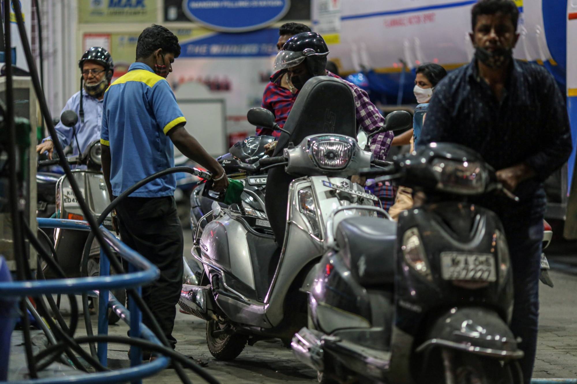 An attendant refuels a customer's motorcycle at a Bharat Petroleum Corp. gas station in Bengaluru, India. | Bloomberg