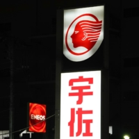 Illuminated signage are displayed at an Idemitsu Kosan Co. gas station (front) and an Eneos gas station, operated by JXTG Nippon Oil & Energy Corp., in Tokyo in November. | BLOOMBERG