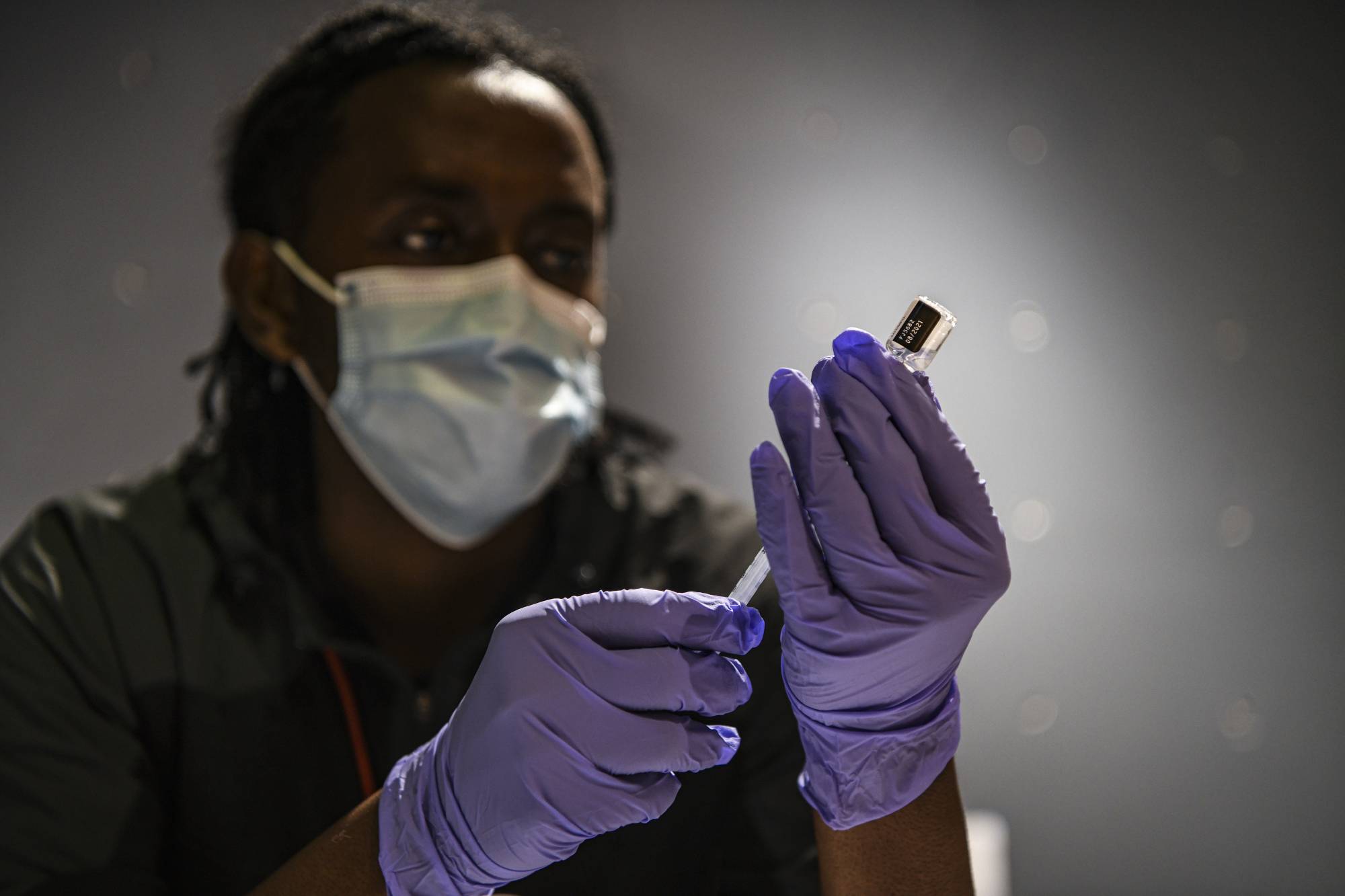 A nurse prepares a COVID-19 vaccine booster in Washington on Feb. 4. Researchers have found that all four vaccines studied, Pfizer-BioNTech, Moderna, Johnson & Johnson and Novavax, produce T cells that retain much of their potency against the omicron variant.  | KENNY HOLSTON/THE NEW YORK TIMES