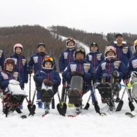 Japan\'s para alpine ski team, including five-time Pyeongchang Games medalist Momoka Muraoka (front, third from left), pose for photos at a competition in Sugadairakogen, Nagano Prefecture, in March 2021. | KYODO