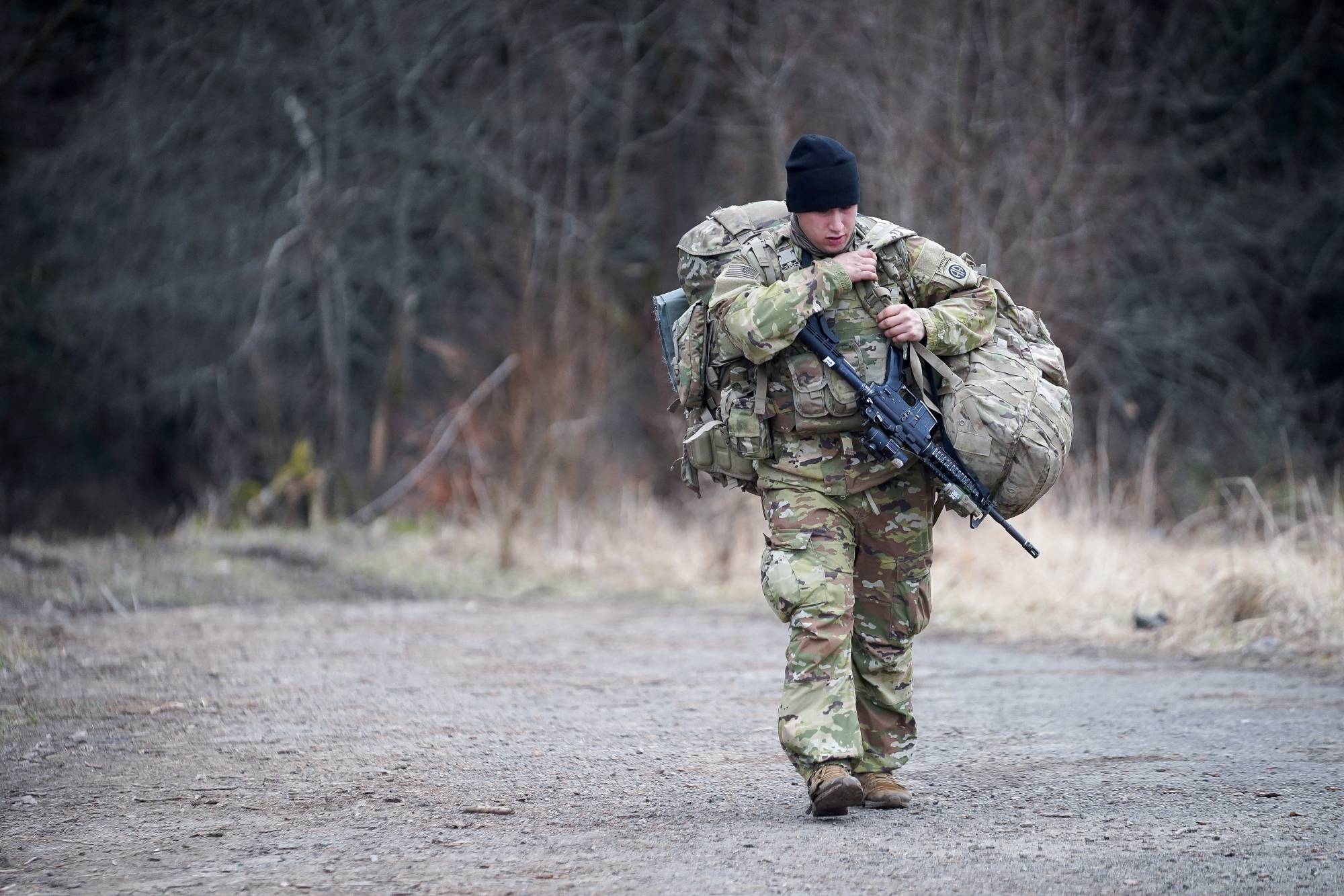 A U.S. Army soldier from the 82nd Airborne Division carries gear at an operating base near Przemysl, Poland, close to the Ukrainian border, on Monday. | REUTERS
