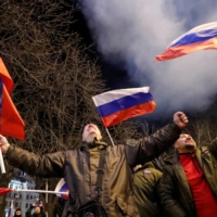Pro-Russian activists celebrate in the city of Donetsk, Ukraine, on Monday after Russian President Vladimir Putin signed a decree recognizing two Moscow-backed breakaway regions in the eastern part of that country as independent entities. | REUTERS 