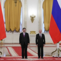 Russian President Vladimir Putin meets with his Chinese counterpart, Xi Jinping, at the Kremlin in June 2019.  Beijing is walking a tightrope now between Russia and the West, seeing the Ukraine invasion as a good distraction from which it could benefit. | REUTERS