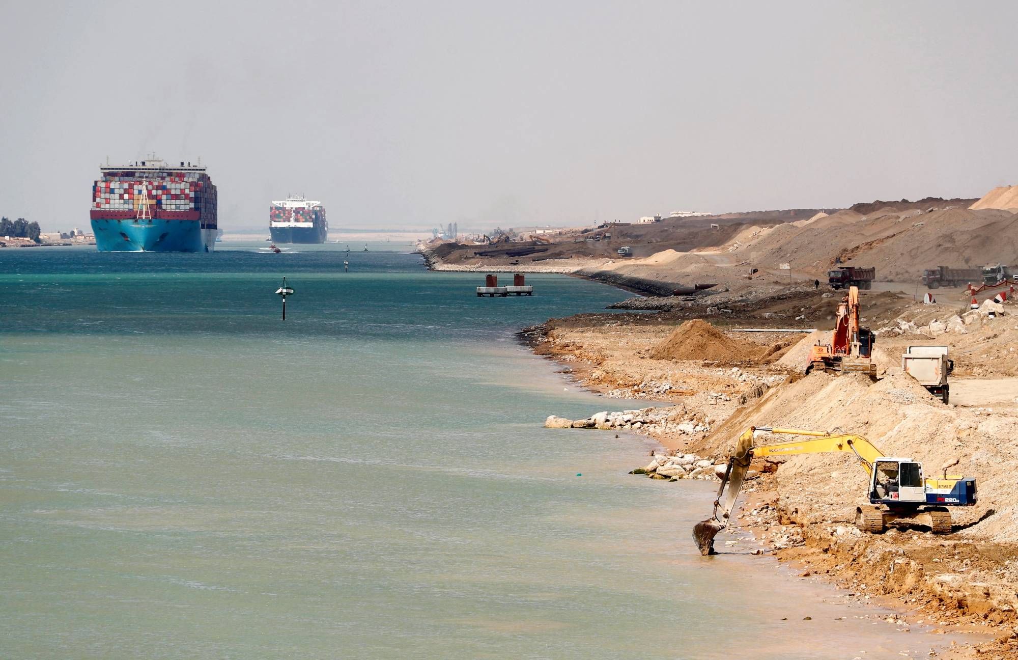 A ship passes through the Suez Canal as excavators work on expanding it, in Suez, Egypt, earlier this month. | Reuters