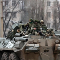 Servicemen ride atop a Russian armored vehicle in Armyansk, Crimea, on Friday.  | AFP-JIJI