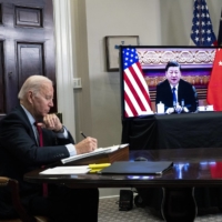 U.S. President Joe Biden takes notes during a video summit with Chinese leader Xi Jinping at the White House in Washington on Nov. 15. American officials presented their Chinese counterparts with intelligence on Russia\'s troop buildup around Ukraine and beseeched Beijing to tell Russia not to invade, according to U.S. officials.  | DOUG MILLS/THE NEW YORK TIMES