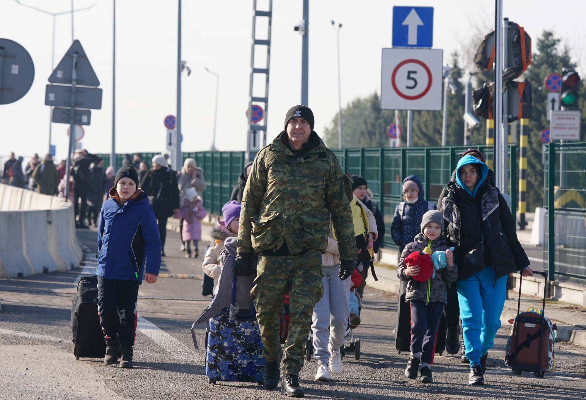 Ukrainians cross the border to Poland at the Korczowa-Krakovets crossing on Saturday following the Russian invasion of Ukraine. | AFP-JIJI