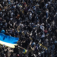 People hold the Ukrainian flag as they gather in Tokyo\'s Shibuya area to protest Russia\'s invasion of Ukraine, on Saturday. | AFP-JIJI