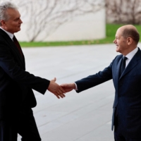 German Chancellor Olaf Scholz and Lithuanian President Gitanas Nauseda shake hands as they meet to discuss sanctions on Russia, in Berlin on Saturday.  | REUTERS