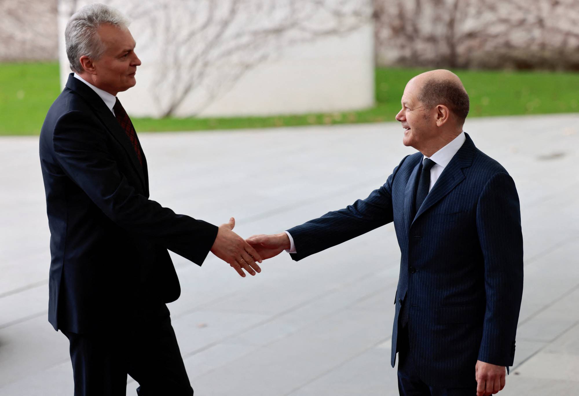German Chancellor Olaf Scholz and Lithuanian President Gitanas Nauseda shake hands as they meet to discuss sanctions on Russia, in Berlin on Saturday.  | REUTERS